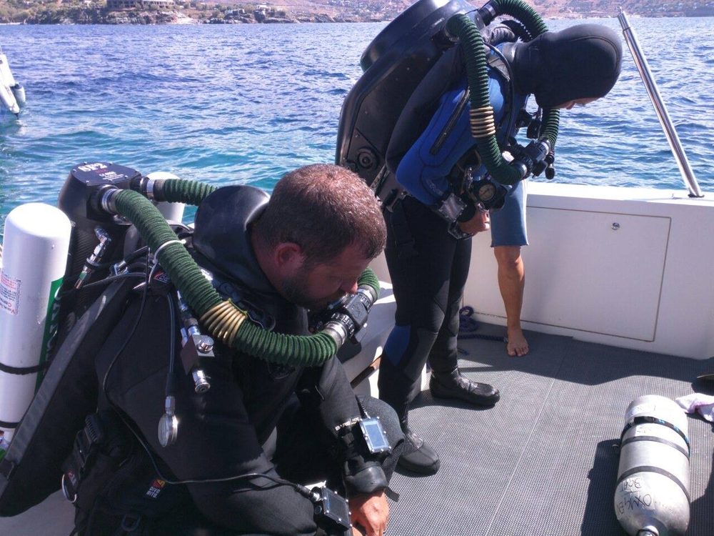 Technical divers preparing equipment on a boat